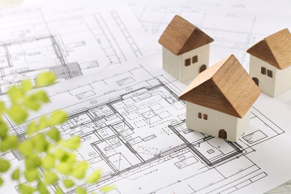 Floor plans under three miniature houses