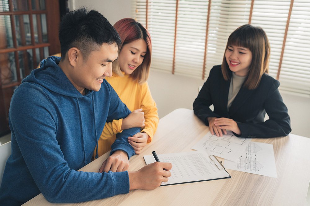 Couple signing documents with the agent